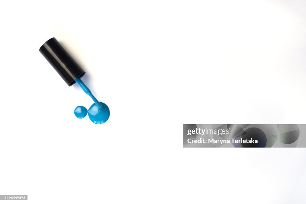Blue nail polish with a brush on a white background.