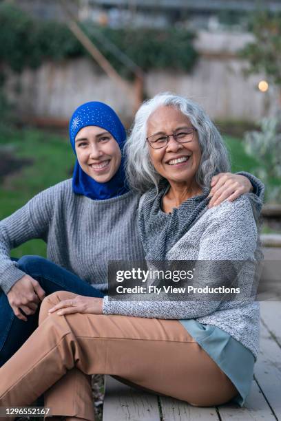 eine schöne erwachsene muslimische frau trägt einen hijab verbringen zeit mit senior erwachsenen freundin im freien - arab community life stock-fotos und bilder