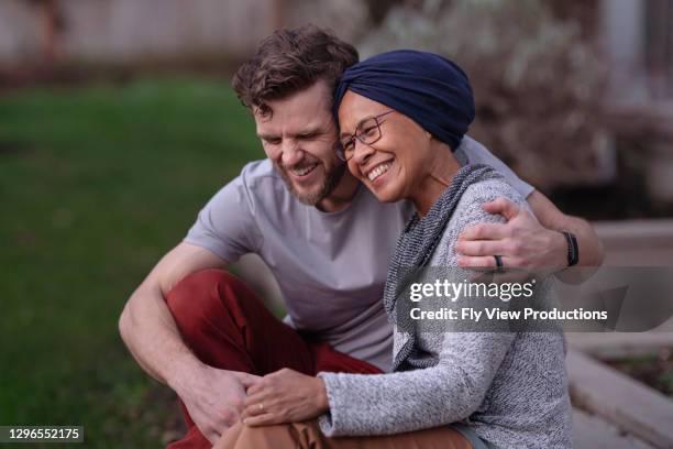 beautiful hawaiian senior woman with cancer embracing her adult son - cancer hope stock pictures, royalty-free photos & images