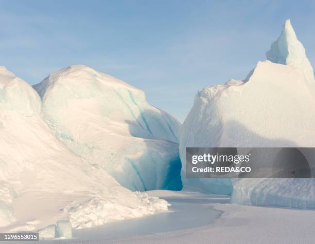 Iceberg frozen into the sea ice of the Melville Bay. Part of the Baffin Bay. Near Kullorsuaq in the far north of West Greenland..