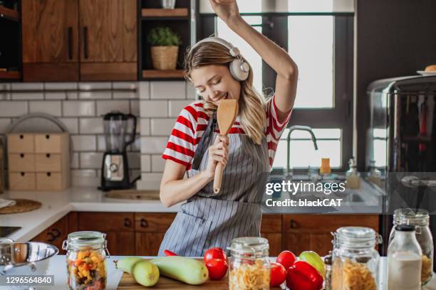 la jeune femme s’amuse dans la cuisine - woman sing photos et images de collection