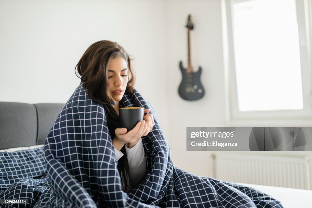 Donna malata sdraiata a letto con febbre alta. Influenza fredda ed emicrania