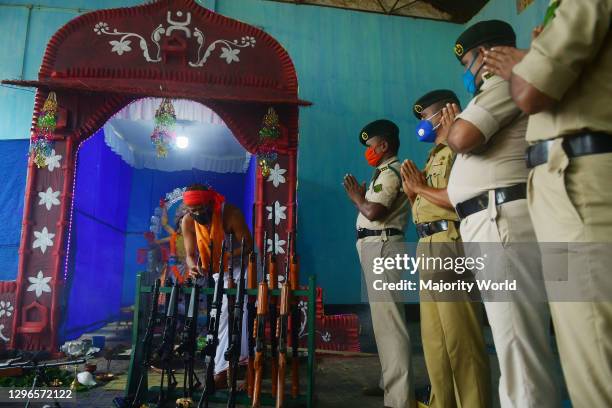 Hindu priest performs prayers and rituals upon weapons of the Tripura State Rifles during the Vishwakarma Puja festival -- when tools are worshipped...