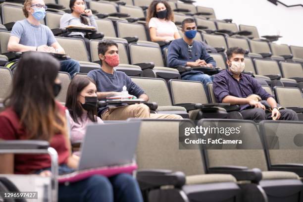 multi ethnic university students in lecture hall - university covid stock pictures, royalty-free photos & images