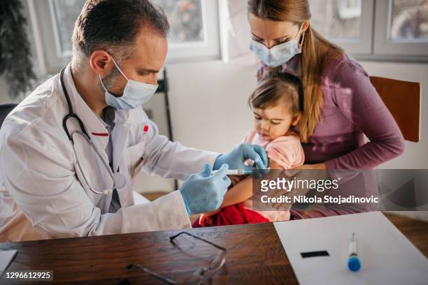 arzt bereitet sich auf die impfung kleines baby mädchen - doctor child cry injection stock-fotos und bilder