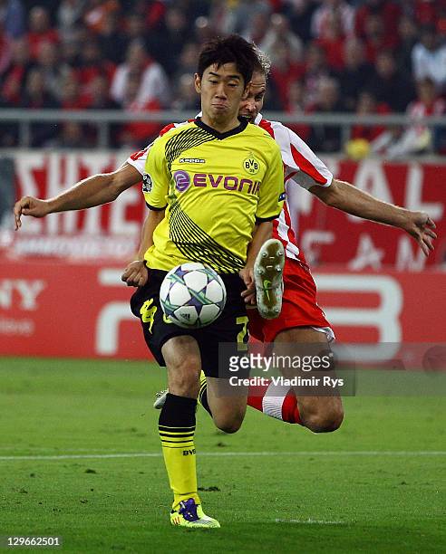 Shinji Kagawa of Dortmund attacks defended by Olof Mellberg of Olympiacos during the UEFA Champions League group F match between Olympiacos FC and...