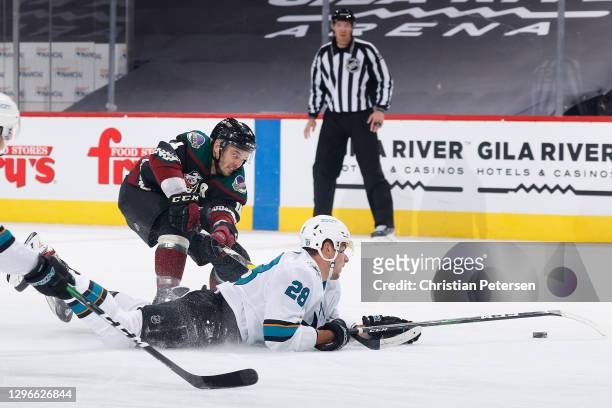 Timo Meier of the San Jose Sharks is taken down by Niklas Hjalmarsson of the Arizona Coyotes during the NHL game at Gila River Arena on January 14,...