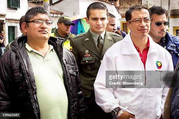 Gustavo Petro, candidate for mayor of Bogota, right, is escorted by bodyguards at a campaign event in Bogota, Colombia, on Saturday, Oct. 15, 2011....