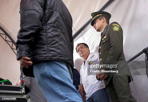 Gustavo Petro, candidate for mayor of Bogota, stands with bodyguards at a campaign event in Bogota, Colombia, on Saturday, Oct. 15, 2011. Petro, the...