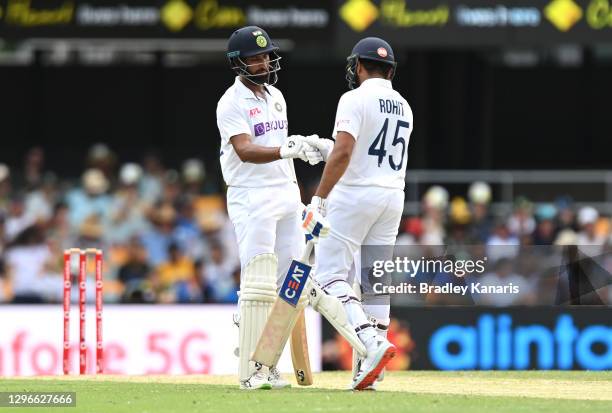 Cheteshwar Pujara of India speaks to Rohit Sharma of India during day two of the 4th Test Match in the series between Australia and India at The...