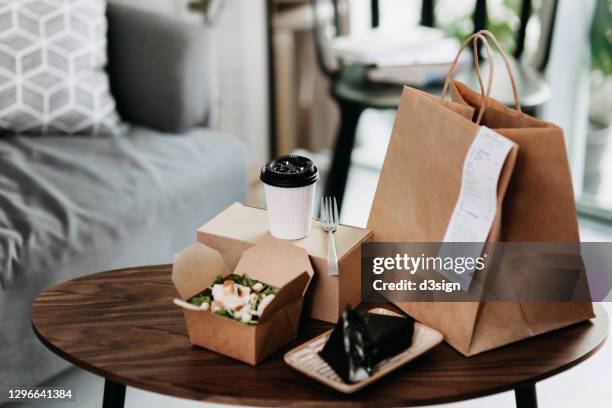 assorted fresh and healthy takeaway meals delivered at home, with healthy grilled chicken vegetable salad, japanese style rice ball / onigiri and a cup of coffee freshly served on the coffee table - hauszustellung stock-fotos und bilder