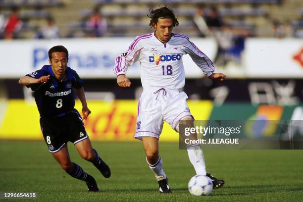 Tony Popovic of Sanfrecce Hiroshima controls the ball under pressure of Hitoshi Morishita of Gamba Osaka during the J.League J1 first stage match...