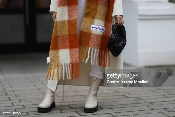 Milena Karl wearing La Marel Jogger, Anine Bing coat, Acne Sudios scarf, Ducie boots and Bottega Veneta bag on January 14, 2021 in Hamburg, Germany.