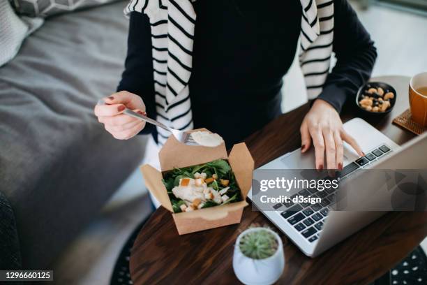 cropped shot of young asian woman eating takeaway meal, a fresh and healthy grilled chicken vegetable salad lunch box while working from home during lunch - telecommuting eating stock pictures, royalty-free photos & images