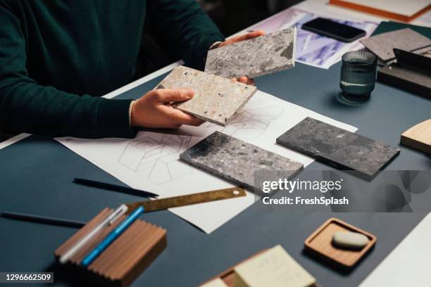 hände eines architekten, der in seinem atelier arbeitet: die wahl von stone flooring samples, eine nahaufnahme - stoffmuster stock-fotos und bilder