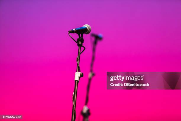 microphone feet with microphones over pink and purple - colour microphone stock-fotos und bilder