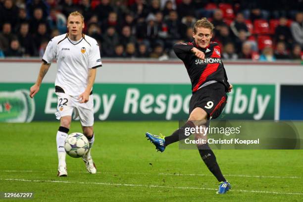 Andre Schuerrle of Leverkusen scores the first goal and Jeremy Mathieu of Valencia watches him during the UEFA Champions League group E match between...