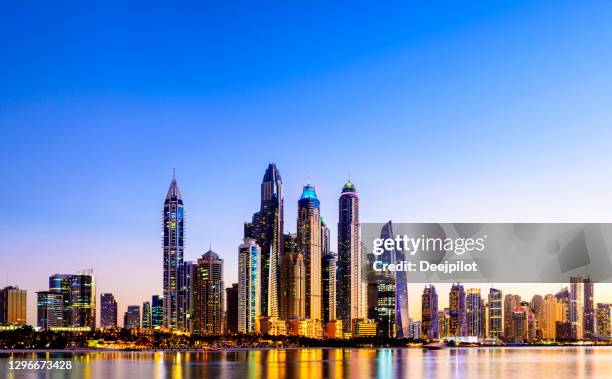 the dubai marina skyscrapers glowing at sunset, united arab emirates - dubai marina stock pictures, royalty-free photos & images