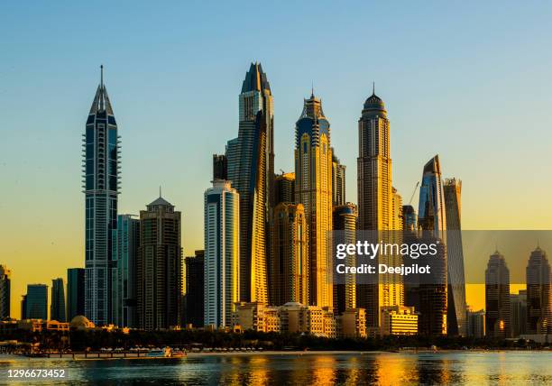 the dubai marina skyscrapers glowing at sunset, united arab emirates - dubai marina stock pictures, royalty-free photos & images