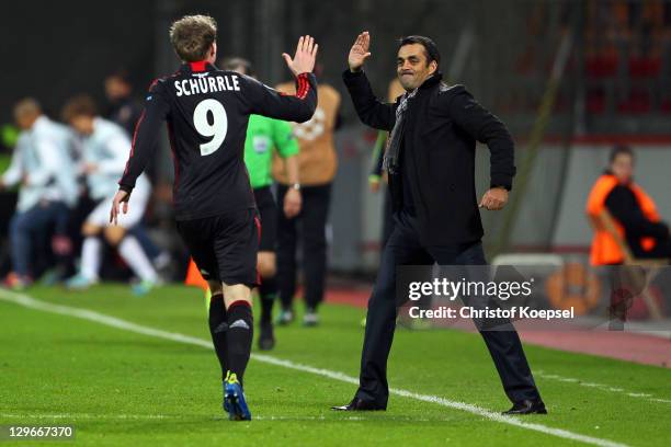 Andre Schuerrle of Leverkusen celebrates the first goalwith head coach Robin Dutt of Leverkusen during the UEFA Champions League group E match...