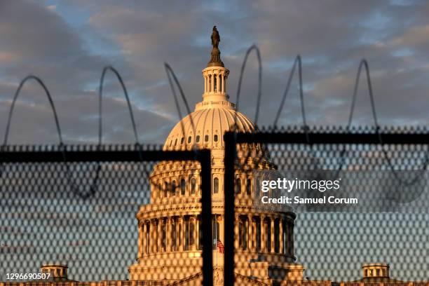 The U.S. Capitol is seen behind a fence with razor wire during sunrise on January 16, 2021 in Washington, DC. After last week's riots at the U.S....