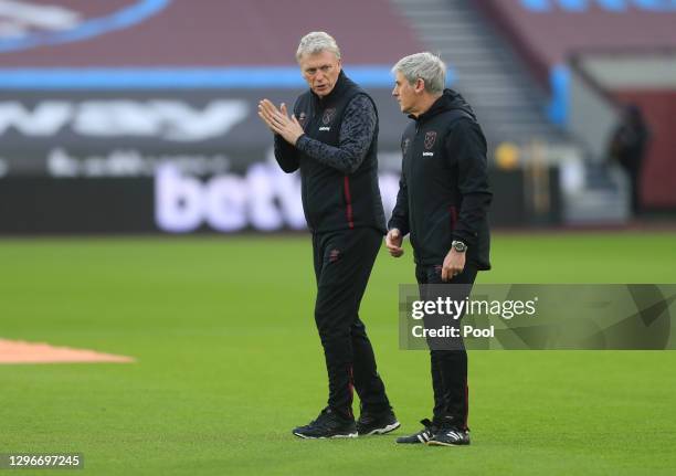 David Moyes, Manager of West Ham United talks with Alan Irvine, Assistant Manager of West Ham United during the warm up prior to during the Premier...