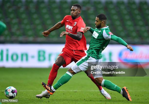 Reece Oxford of FC Augsburg is challenged by Jean-Manuel Mbom of SV Werder Bremen during the Bundesliga match between SV Werder Bremen and FC...