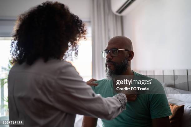 doctor listening to patient's heartbeat during home visit - cardiopulmonary system stock pictures, royalty-free photos & images