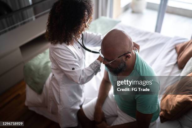 arts die aan de hartslag van de patiënt tijdens huisbezoek luistert - lung doctor patient stockfoto's en -beelden