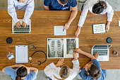 Overhead view of healthcare workers discussing x-ray image
