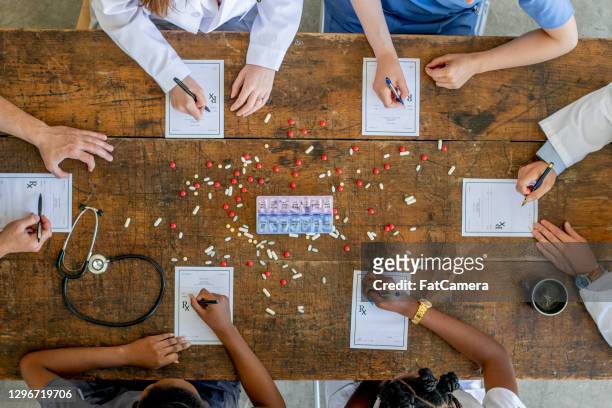 overhead view of pharmacists meeting together - civilian stock pictures, royalty-free photos & images