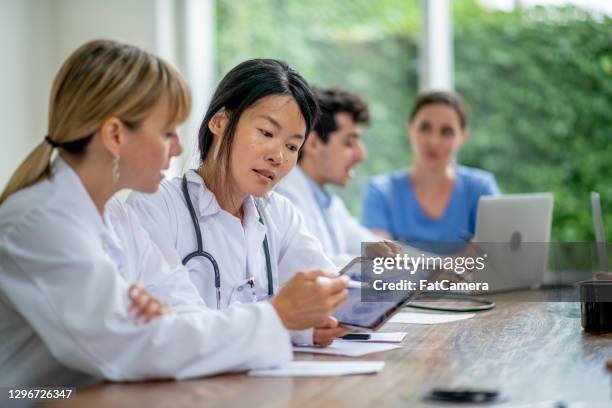 medical professionals working together in a meeting - civilian stock pictures, royalty-free photos & images