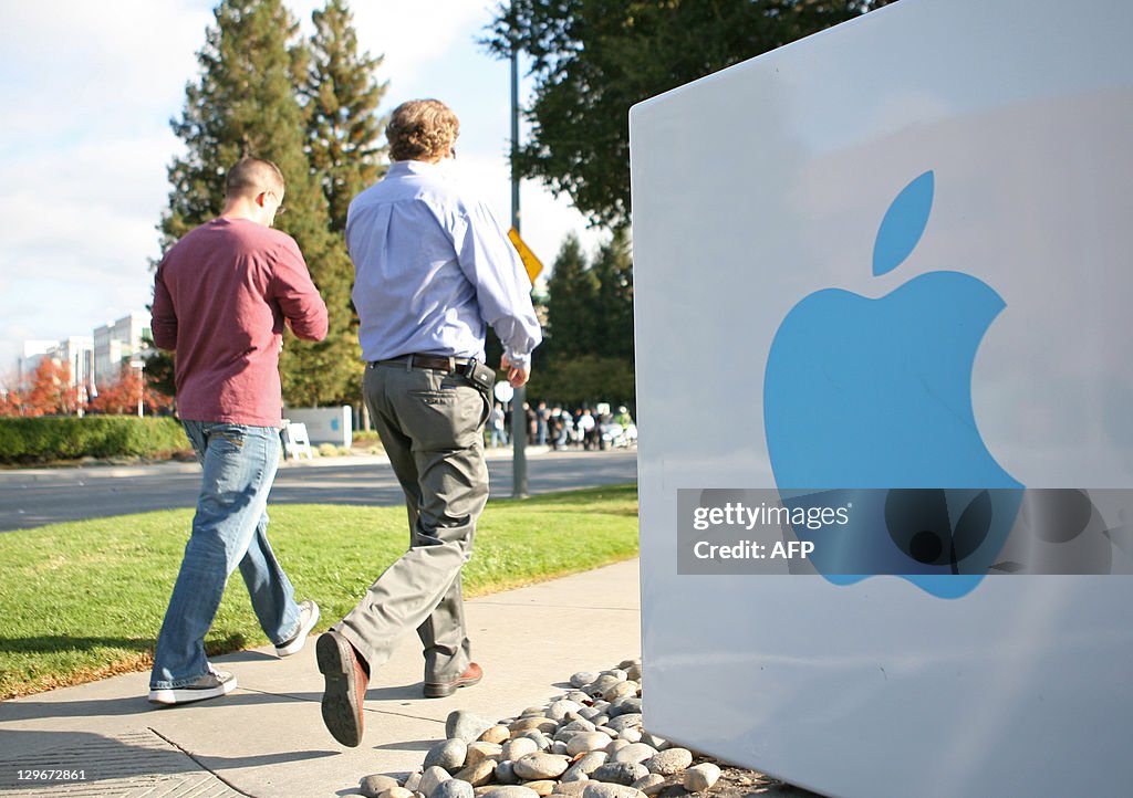 Apple employees walk towards the Apple H