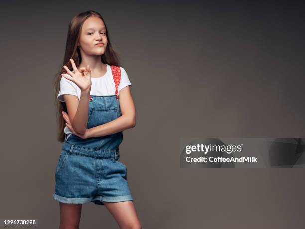 kleines mädchen trägt lätzchen overalls - petite young models stock-fotos und bilder