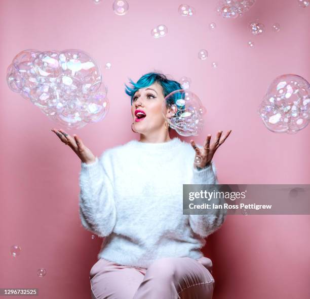 beautiful woman with blue hair catching bubbles - bubble wand foto e immagini stock