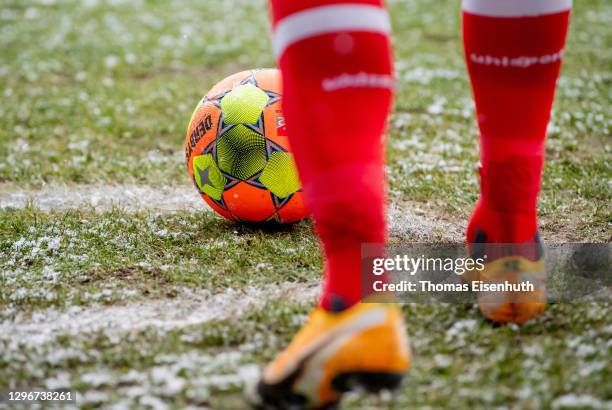 An orange ball is pictured on the green with snow during the Second Bundesliga match between FC Erzgebirge Aue and Fortuna Düsseldorf at...