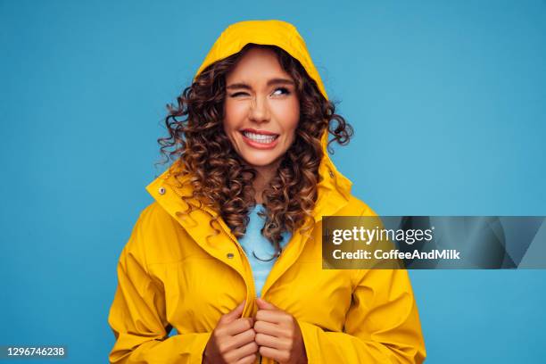 smiling beautiful woman in raincoat - waterproof clothing stock pictures, royalty-free photos & images