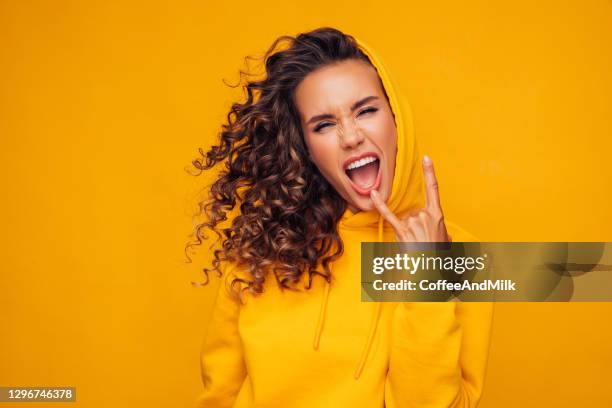 beautiful girl in a yellow sweater - horn sign stock pictures, royalty-free photos & images