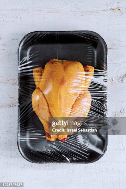 from above of a raw chicken packed in a plastic container. no plastic concept - chicken wrap stock-fotos und bilder