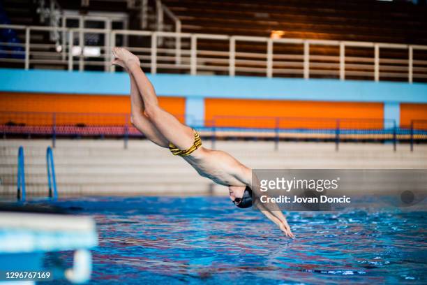 profi-schwimmer springt in den watter - schwimmer startblock stock-fotos und bilder