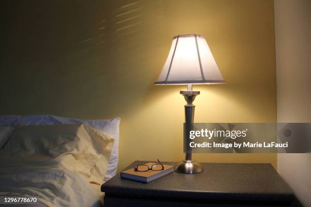 bedroom night table with lamp, book and reading glasses - electric lamp 個照片及圖片檔