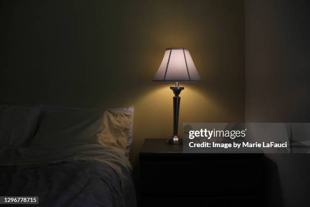 dark bedroom with illuminated light - reading glasses on table stock pictures, royalty-free photos & images