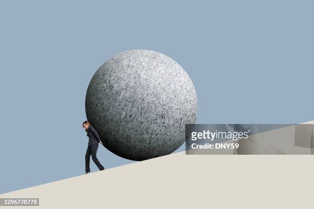 businesswoman pushes a sphere up a hill - uphill stock pictures, royalty-free photos & images