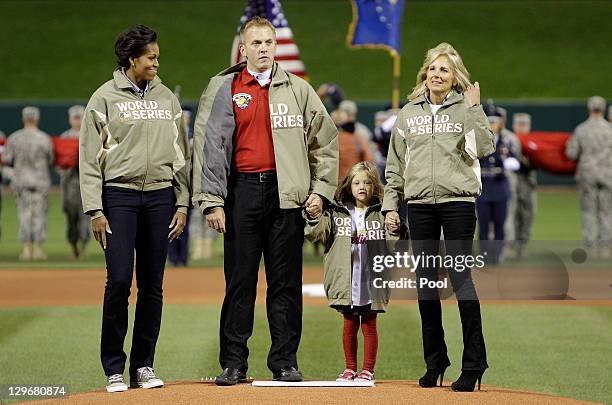 First lady Michelle Obama, Iraq war veteran James Sperry, daughter Hannah and Dr. Jill Biden walk off the mound prior to the start of Game One of the...