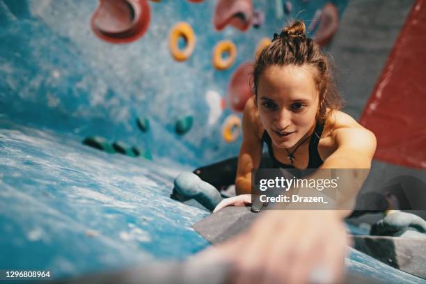 high angle view of skinny strong woman climbing on boulder wall - chalk wall stock pictures, royalty-free photos & images