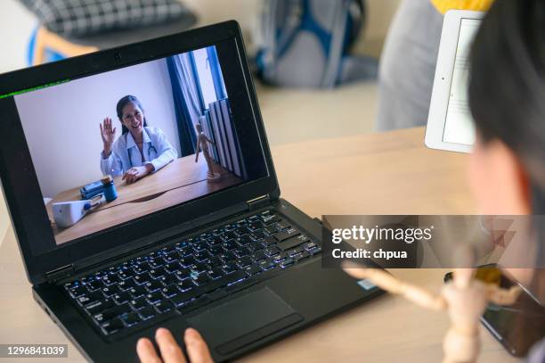 asian female doctor attending video conference from home - virtual visit stock pictures, royalty-free photos & images