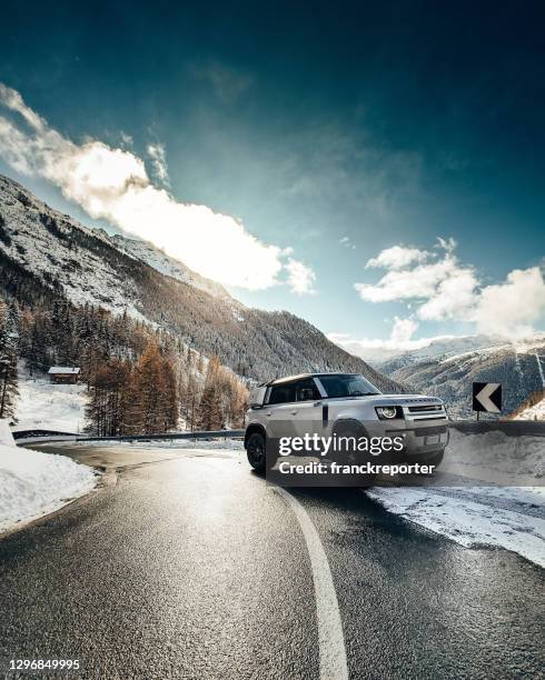 new land rover defender on a snowed road in courmayeur - sports utility vehicle stock pictures, royalty-free photos & images