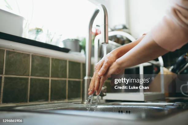 close up of an asian woman washing her hands in the kitchen - washing hands close up stock pictures, royalty-free photos & images