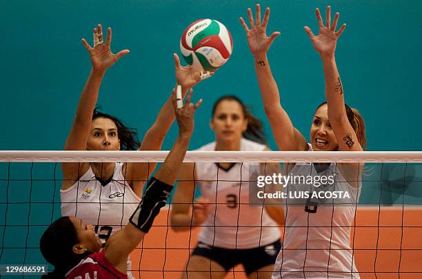 Brazil's Sheila Castro and Thaisa Menezes block the ball against Milagros Cabral of the Domican Republic during their semifinal volleyball match at...