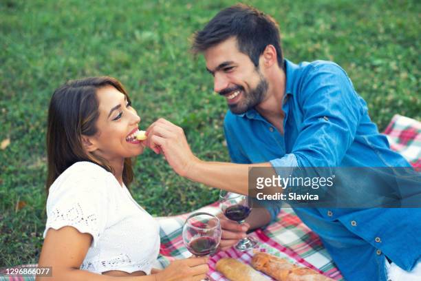 jong paar op de picknick - eating cheese stockfoto's en -beelden